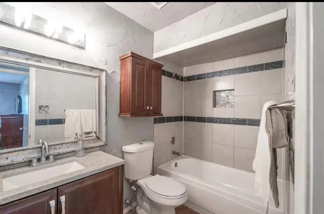 a bathroom with a granite countertop sink toilet and shower