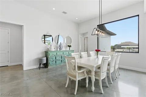 a dining room with furniture water view and a floor to ceiling window