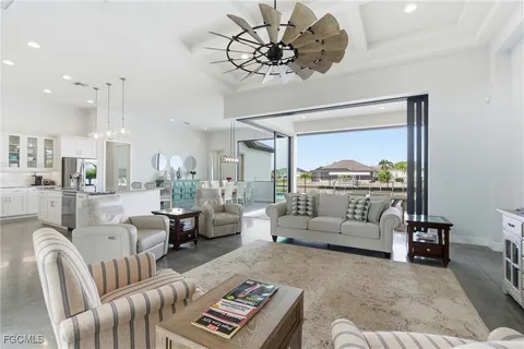 a living room with furniture a chandelier and a flat screen tv