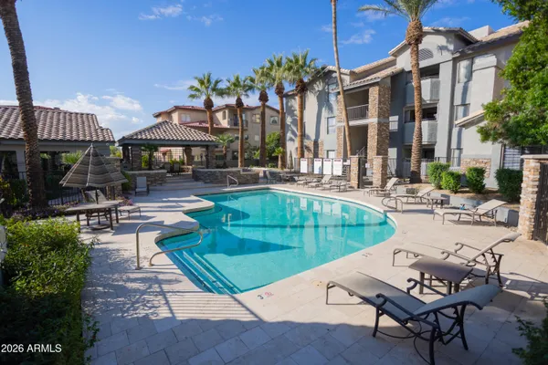 a view of a patio with couches table and chairs under an umbrella