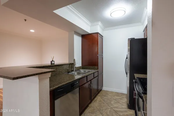 a kitchen with stainless steel appliances granite countertop a refrigerator and a stove