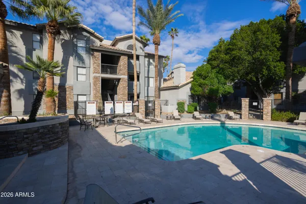a view of a house with pool and sitting area