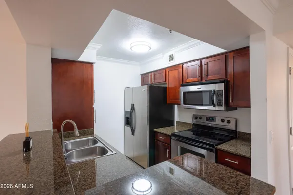 a kitchen with stainless steel appliances granite countertop a refrigerator and a stove top oven