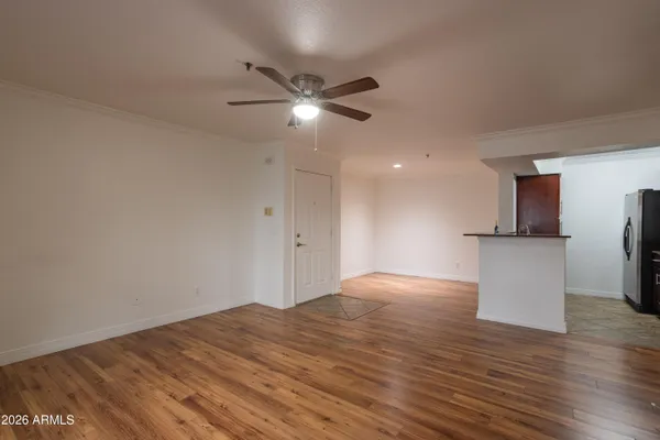 a view of empty room with wooden floor and ceiling fan
