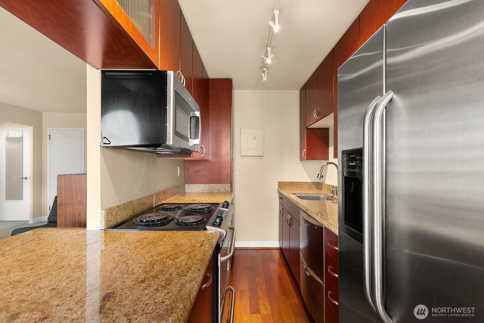 1105 Spring Street, Unit 1106 Seattle, WA 98104 - Photo 6 of 11 a kitchen with stainless steel appliances granite countertop a refrigerator a stove and a sink