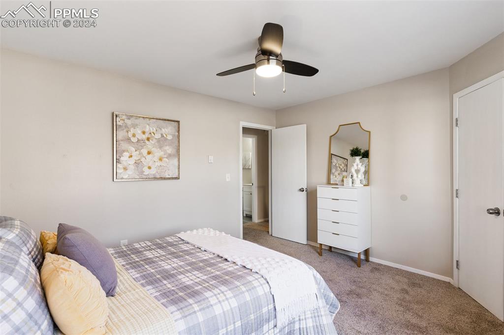 773 Alexander Road, Unit B Colorado Springs, CO 80909 - Photo 11 of 16 a bedroom with a bed and a chandelier