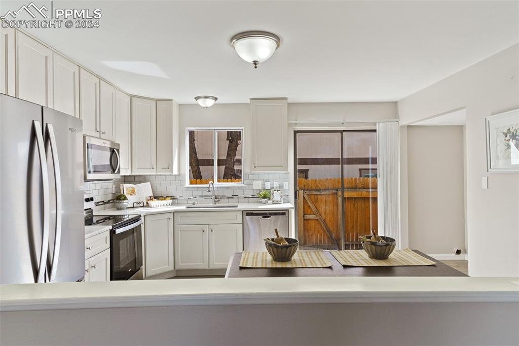 773 Alexander Road, Unit B Colorado Springs, CO 80909 - Photo 6 of 16 a kitchen with a refrigerator and a sink
