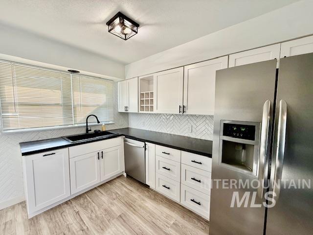 1139 Webster Street Clarkston, WA 99403 - Photo 14 of 34 Kitchen featuring stainless steel appliances, white cabinets, dark countertops, and light wood finished floors