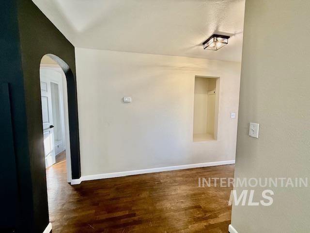 1139 Webster Street Clarkston, WA 99403 - Photo 20 of 34 Unfurnished room with arched walkways and dark wood-style floors