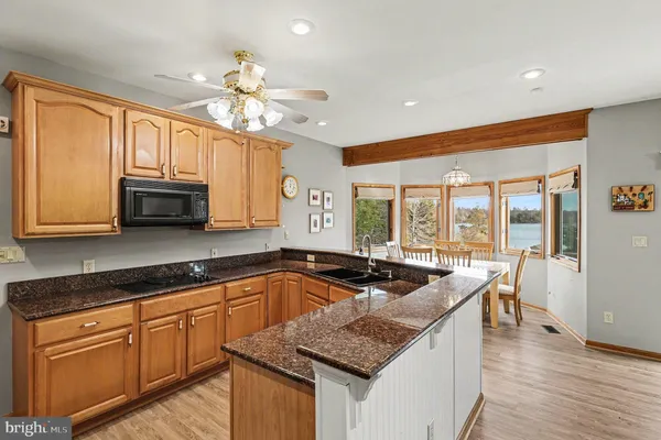 a kitchen with granite countertop a sink a counter top space and living room area