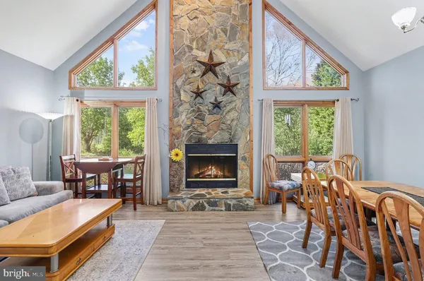 a living room with furniture a large window and a fireplace