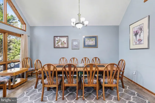 a view of a dining room with furniture a chandelier and a window