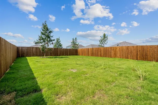 a view of yard with swimming pool and wooden fence