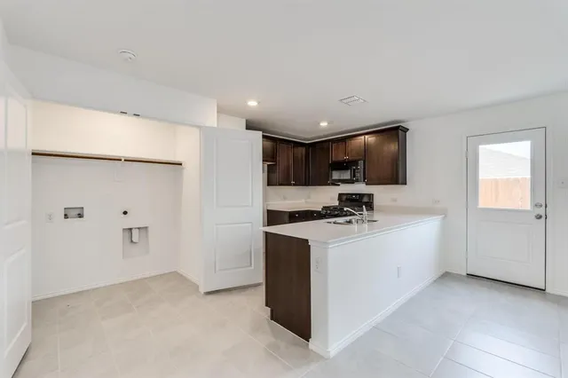 a kitchen with stainless steel appliances a stove a refrigerator a sink and white cabinets