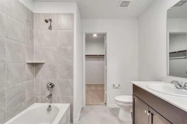 a bathroom with a granite countertop sink a toilet and shower
