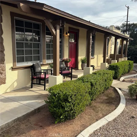 a front view of a house with outdoor seating and plants