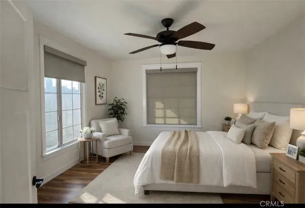 a bedroom with a large bed chandelier and a window