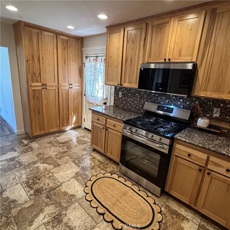 a kitchen with stainless steel appliances granite countertop a refrigerator sink and stove