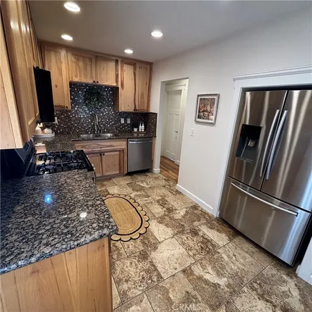 a kitchen with stainless steel appliances granite countertop a refrigerator sink and cabinets