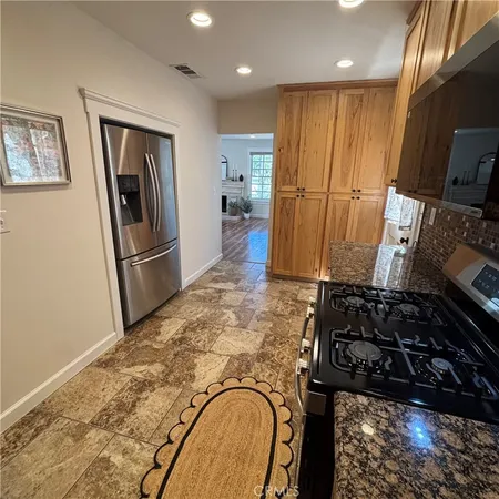 a kitchen with stainless steel appliances granite countertop a stove a sink and a microwave