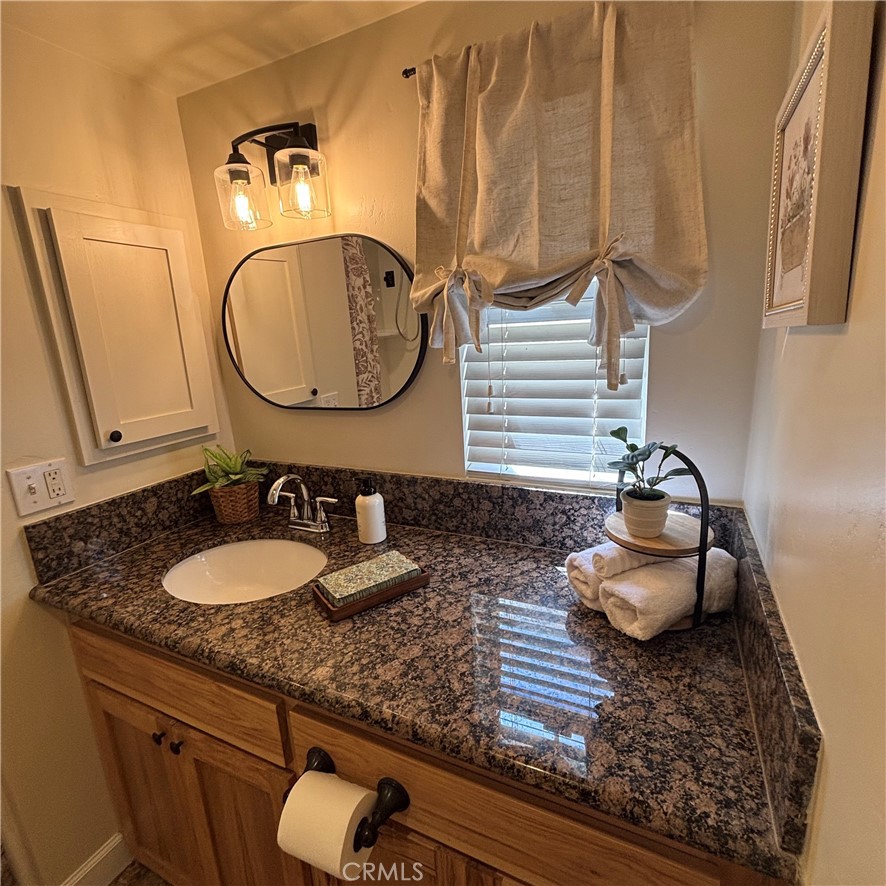 5012 Brockton Avenue Riverside, CA 92506 - Photo 23 of 28 a bathroom with a granite countertop sink and a mirror