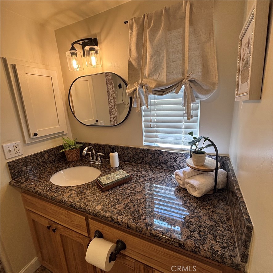 5012 Brockton Avenue Riverside, CA 92506 - Photo 24 of 28 a bathroom with a granite countertop sink and a mirror