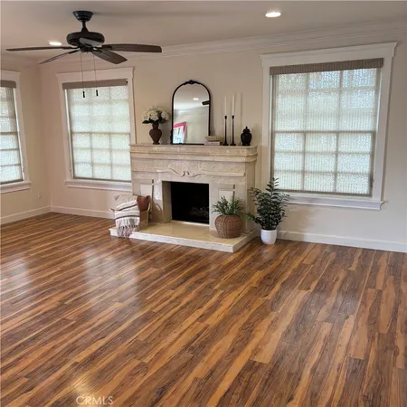 wooden floor fireplace and windows in an empty room