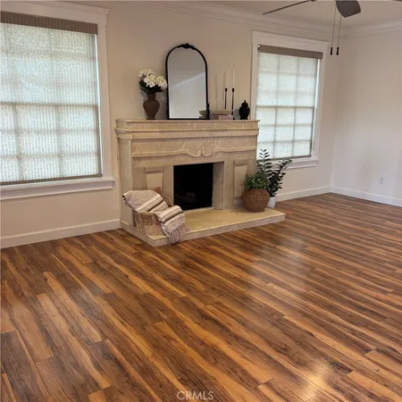 a view of a livingroom with wooden floor and a fireplace