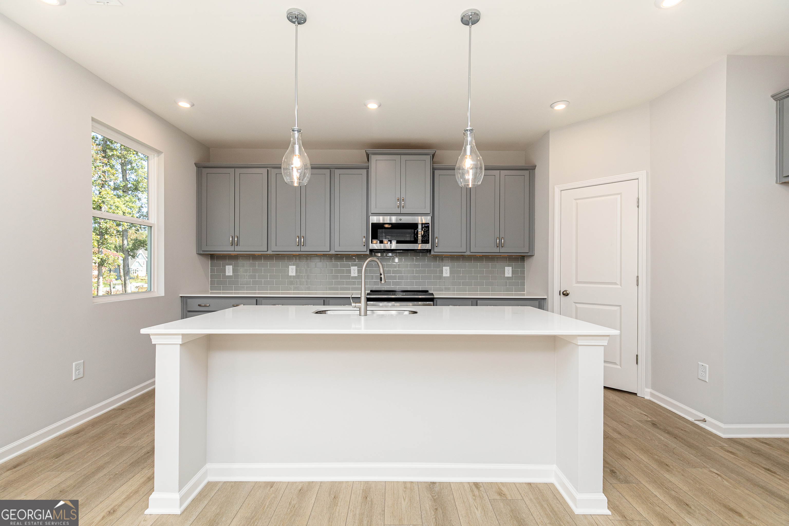 732 Coventry Cv Way Acworth, GA 30102 - Photo 11 of 41 a kitchen with kitchen island a stove a sink a center island and wooden floor