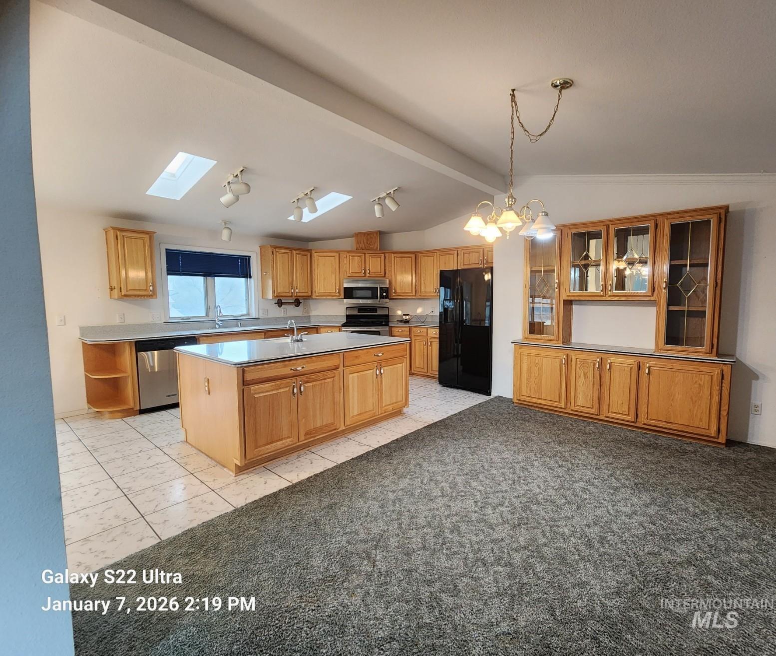 650 Ash Street Vale, OR 97918 - Photo 17 of 23 Kitchen featuring a skylight, appliances with stainless steel finishes, an island with sink, open shelves, and hanging light fixtures