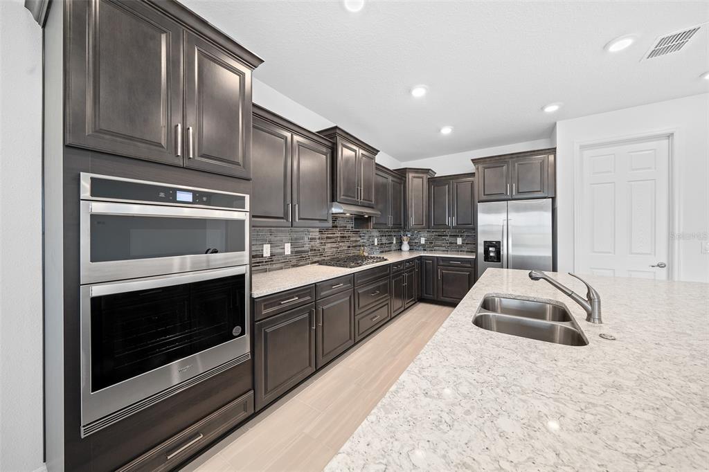 6303 Southwest 75th Ct Road Ocala, FL 34474 - Photo 11 of 50 a kitchen with granite countertop white cabinets stainless steel appliances and sink