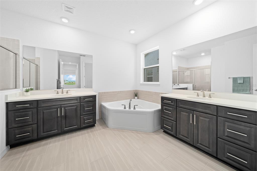 6303 Southwest 75th Ct Road Ocala, FL 34474 - Photo 23 of 50 a spacious bathroom with a tub sink double vanity granite and a bathtub