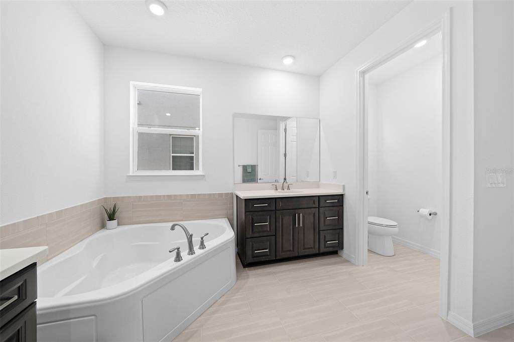 6303 Southwest 75th Ct Road Ocala, FL 34474 - Photo 24 of 50 a spacious bathroom with a tub sink toilet and mirror