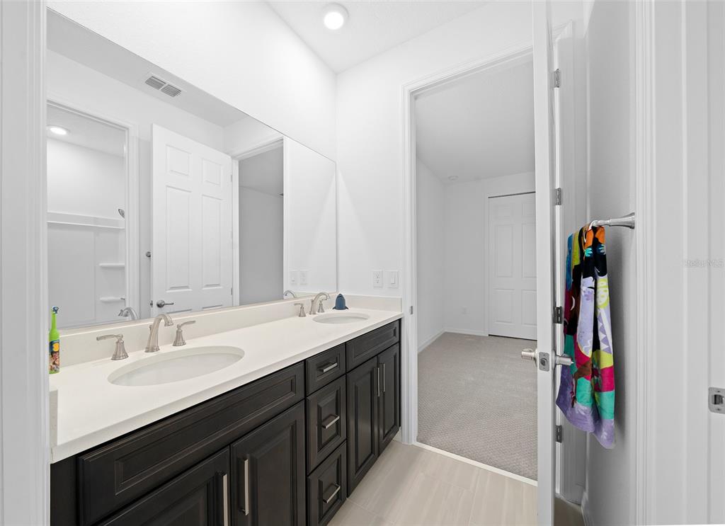 6303 Southwest 75th Ct Road Ocala, FL 34474 - Photo 35 of 50 a en suite bathroom with a double vanity sink a and a mirror