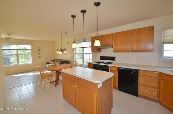 a kitchen with a stove a sink a counter and chairs