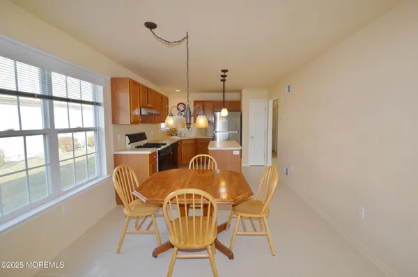 a dining room with furniture a chandelier and window