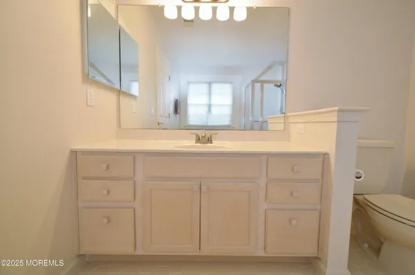 a bathroom with a toilet sink and mirror