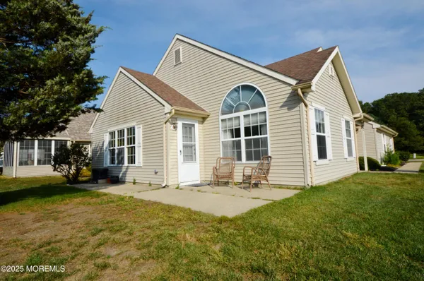 a front view of a house with a yard and potted plants
