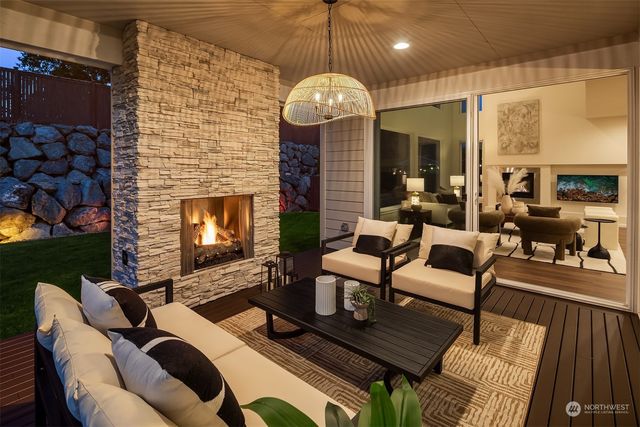 a living room with furniture a fireplace and a floor to ceiling window