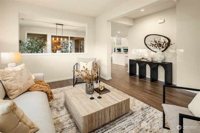 a living room with furniture a clock on wall and a window