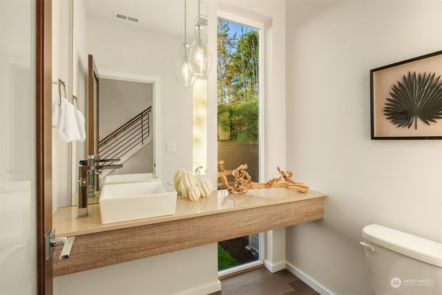 a bathroom with a sink a toilet and a large mirror