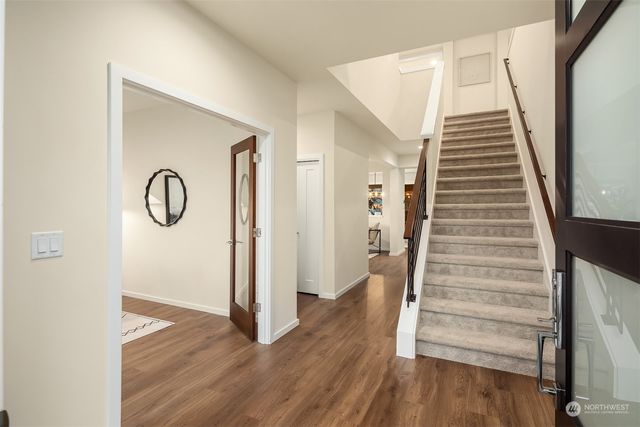 a view of a hallway with wooden floor and entryway