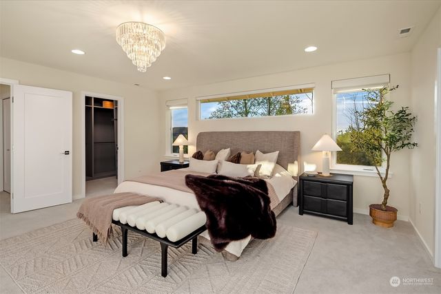 a spacious bedroom with a bed and a chandelier