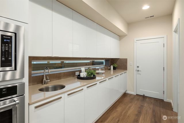a kitchen with stainless steel appliances a sink and a refrigerator