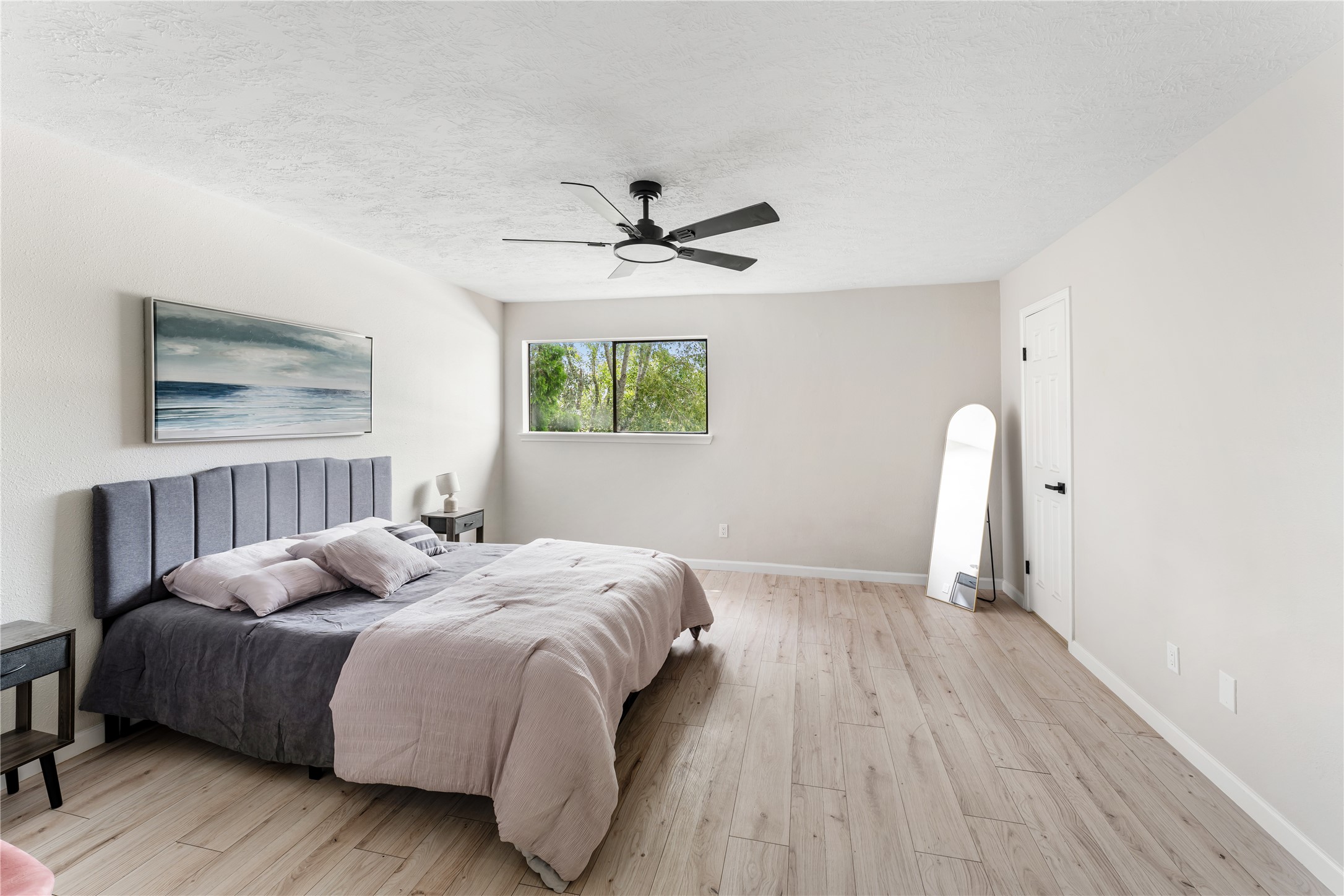 9425 Fondren Road Houston, TX 77074 - Photo 20 of 29 On the second floor, the spacious main bedroom features a modern design with light wood flooring, new ceiling fan and neutral walls.