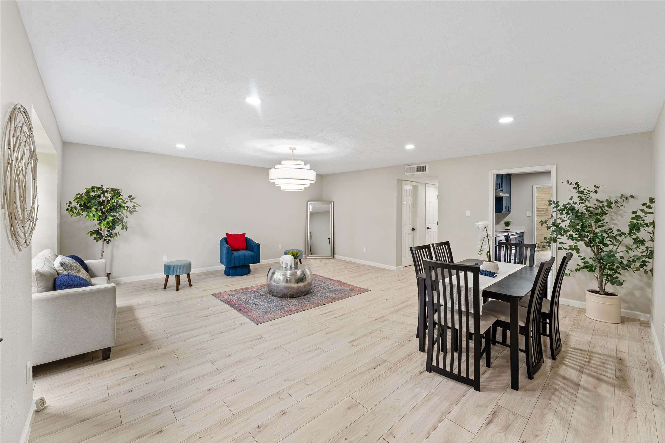 9425 Fondren Road Houston, TX 77074 - Photo 3 of 29 Upon entering the home, you're welcomed by this spacious living and dining area, featuring light wood flooring, neutral walls, modern recessed lighting and a beautiful chandelier