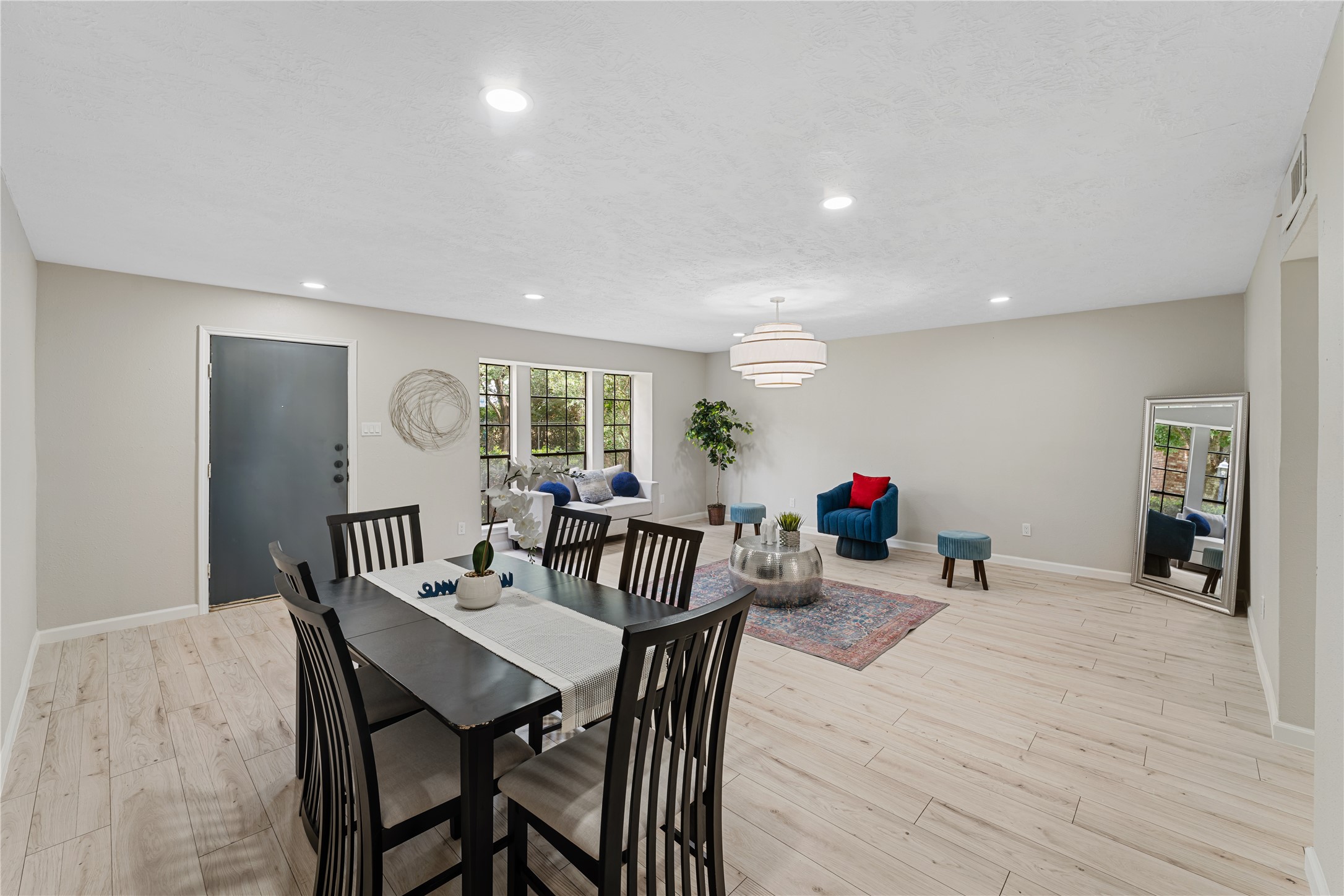 9425 Fondren Road Houston, TX 77074 - Photo 5 of 29 This spacious, open-concept living and dining area features light wood flooring, neutral walls, and ample natural light from large windows.