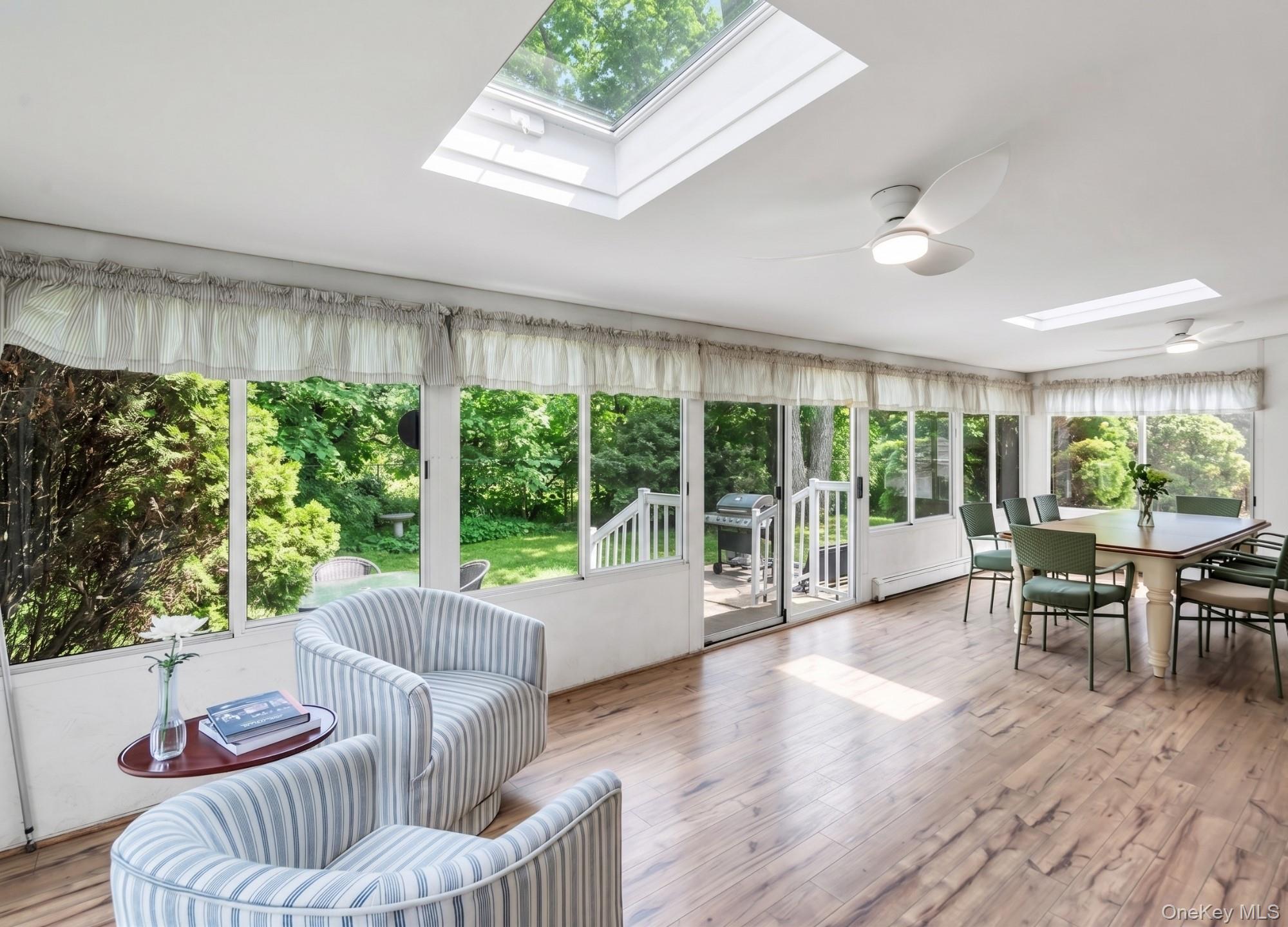 5845 North Bayview Road Southold, NY 11971 - Photo 13 of 26 4 season sunroom featuring panoramic windows with views of serene protected woodlands and skylights