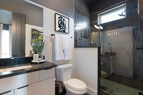 a bathroom with a sink a toilet a mirror and shower