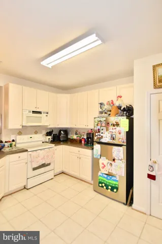 a kitchen with stainless steel appliances kitchen island granite countertop a refrigerator and a stove top oven